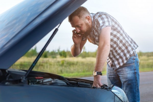 autopom! extended car warranty man on mobile phone car breakdown by the side of the road man checking under the hood 